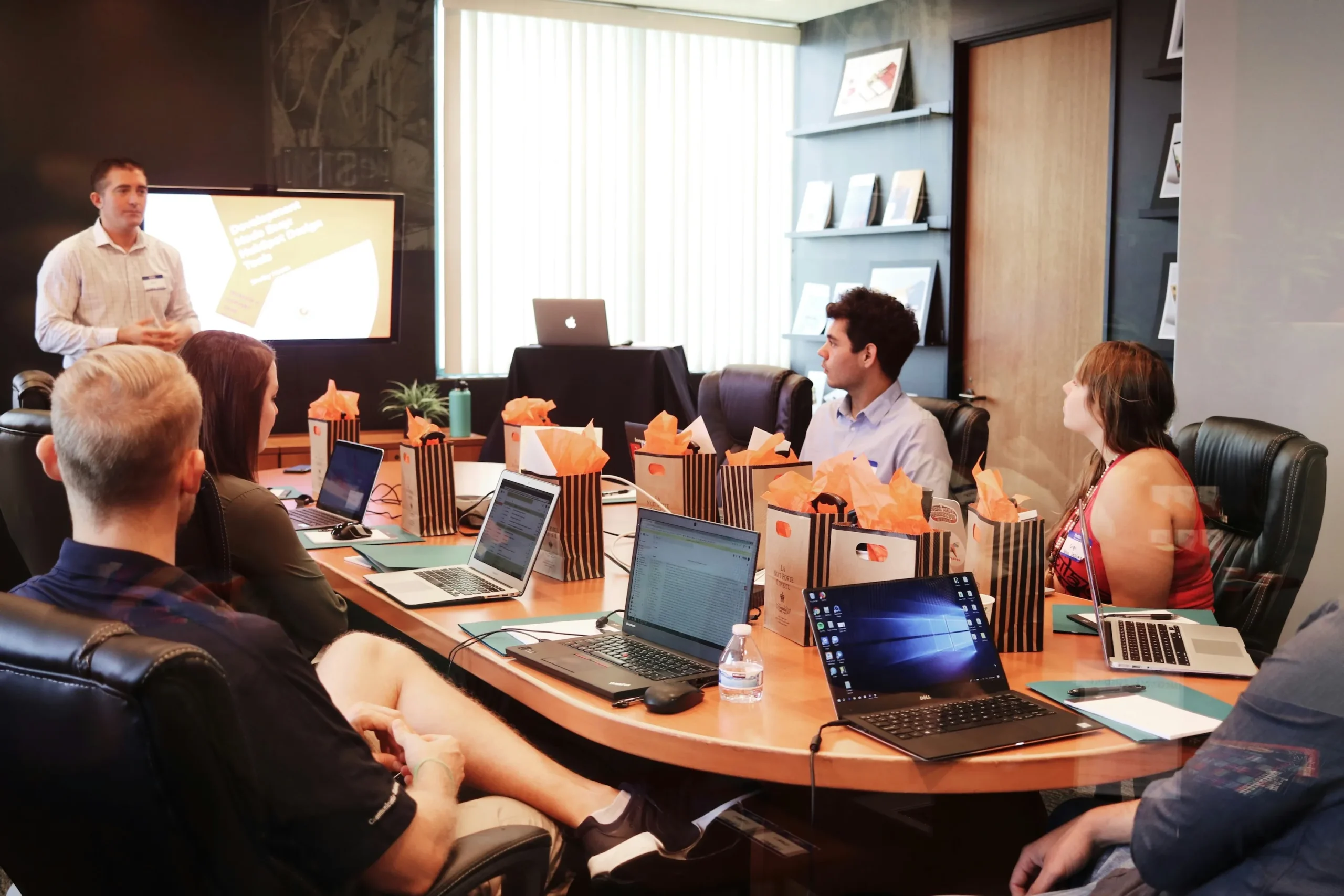 Team in a boardroom reviewing maritime IT strategy on laptops during a consulting session